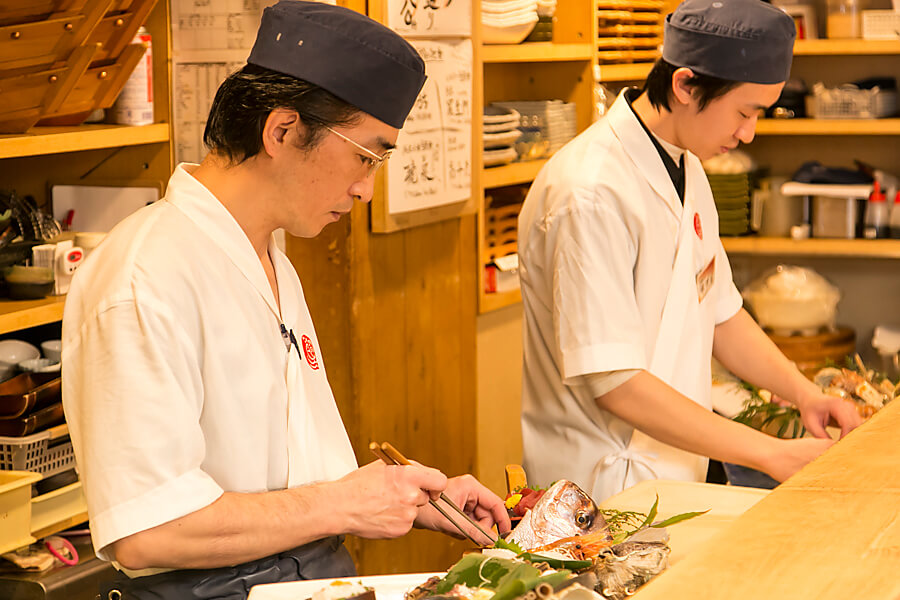 魚を捌く料理人